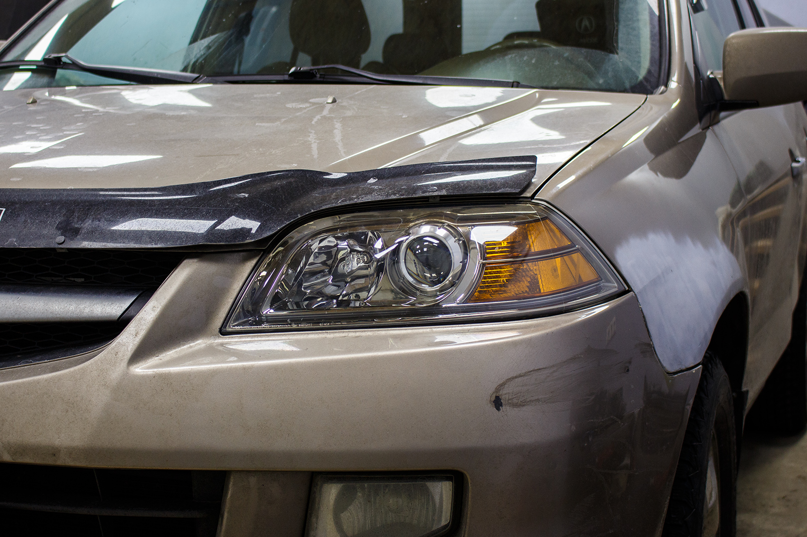 Зовнішній вигляд лівої фари Acura MDX ПІСЛЯ заміни штатних лінз на Hella 5, шліфування, полірування та бронювання поліуретановою плівкою