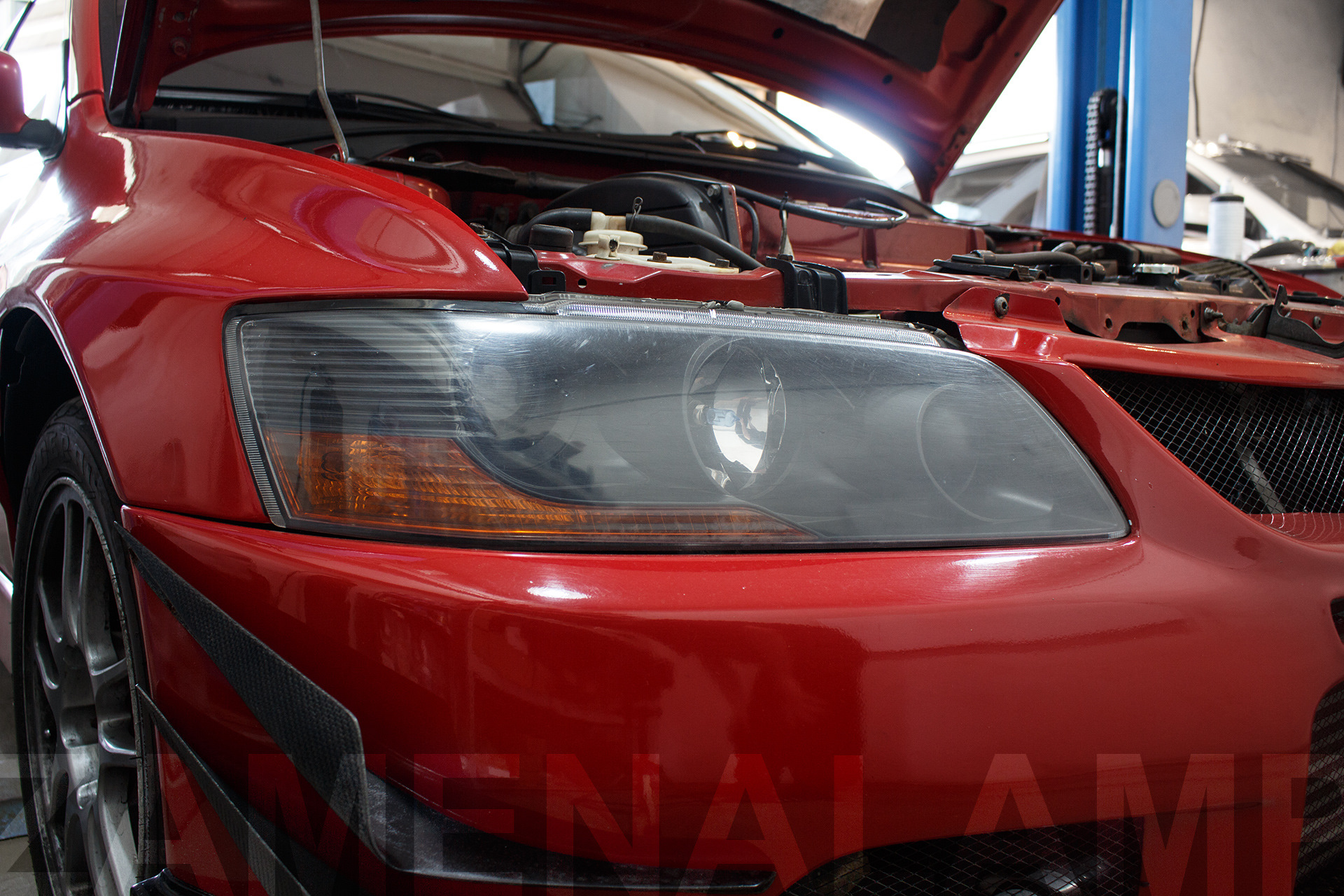 Зовнішній вигляд лівої фари Mitsubishi Lancer EVO IX ДО заміни штатних лінз на біксенонові лінзи Koito Q5